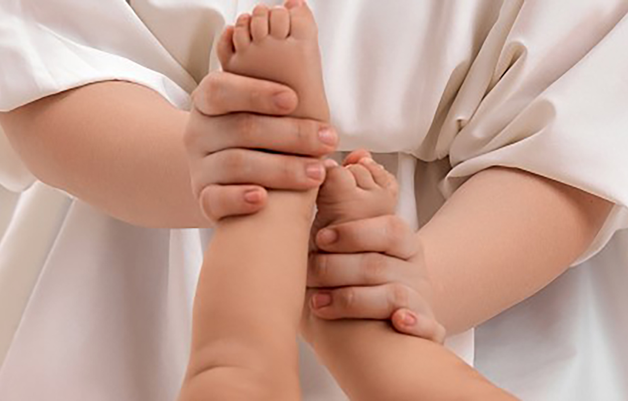 someone massaging baby's feet